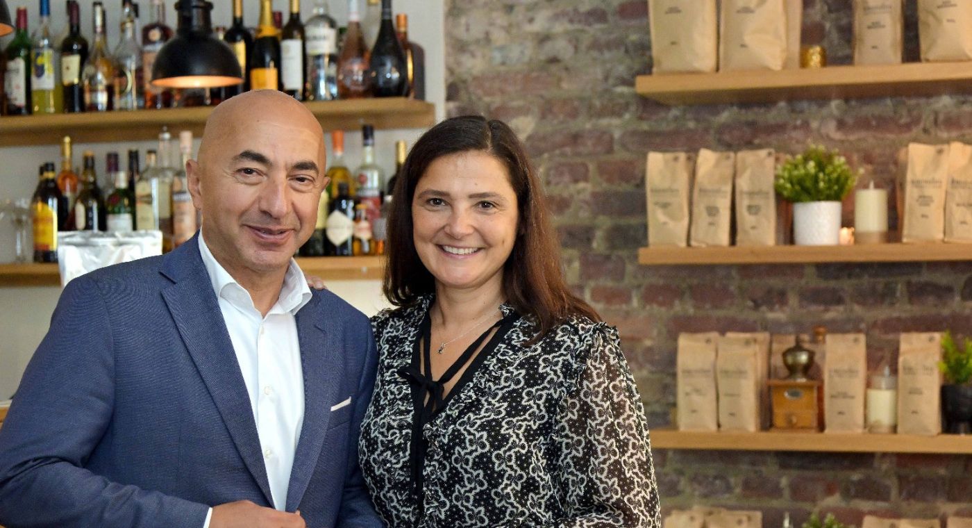 Ein Mann und eine Frau stehen nebeneinander in einem Ladenlokal und lächeln.