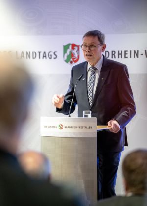 Ein Mann im Anzug steht an einem Podium.