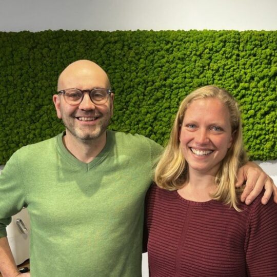 Ein Mann und eine Frau lachen in die Kamera.