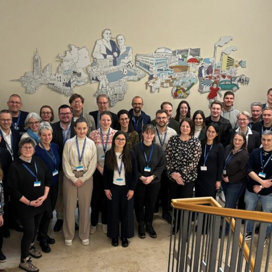 Gruppenfoto im Treppenhaus vor einer hellen Wand