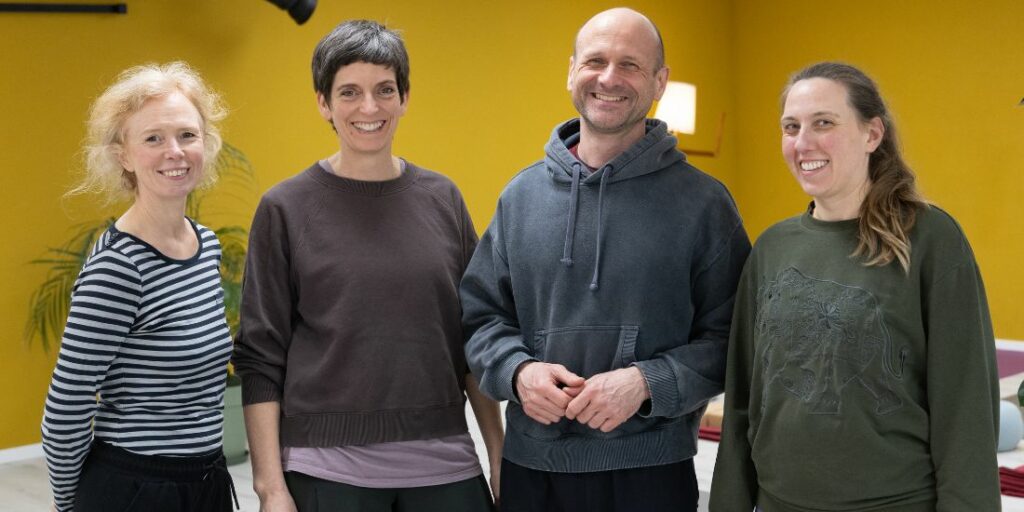 Gruppenfoto von vier Personen in einem Yoga-Studio
