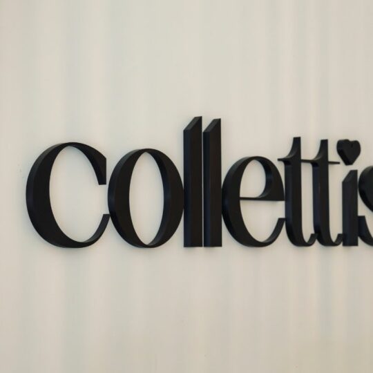 An einer Wand hängt in dunklen Buchstaben das Wort "collettis". Auf dem "i" ist ein Herz.