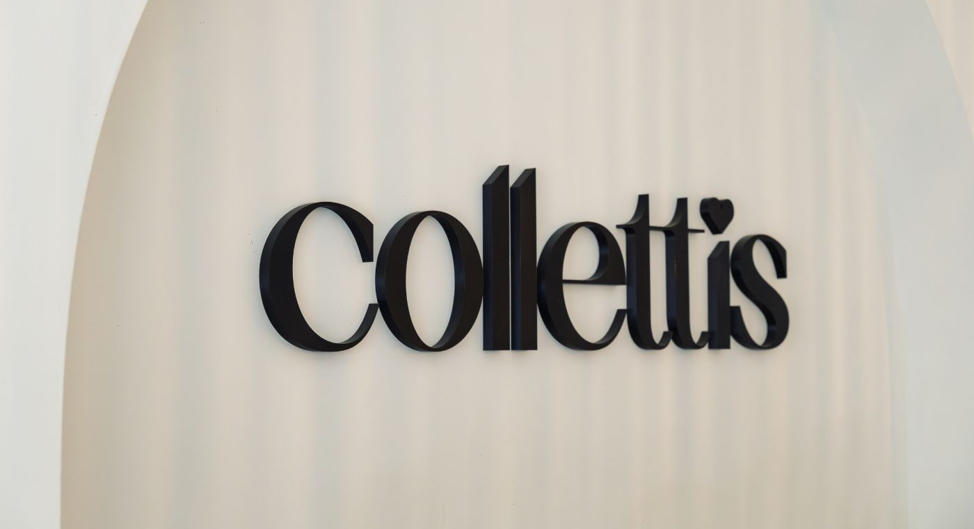 An einer Wand hängt in dunklen Buchstaben das Wort 