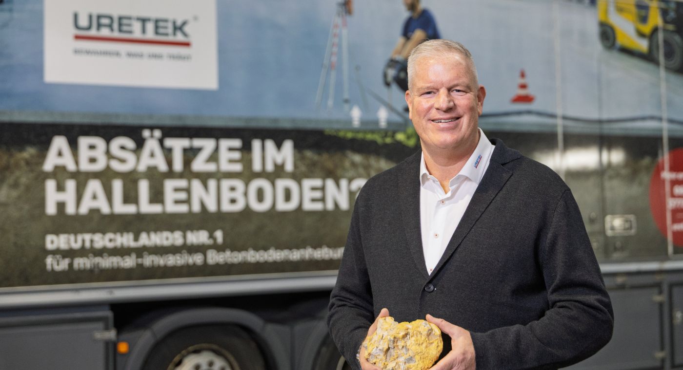 Ein Mann steht vor einem LW und lächelt in die Kamera.