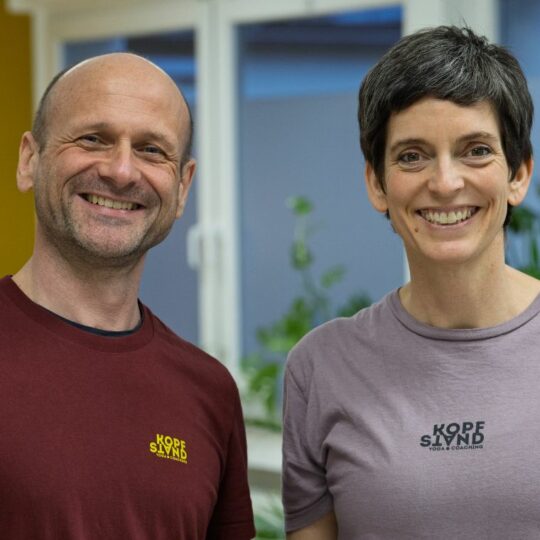 Ein Mann und eine Frau stehen nebeneinander und lächeln in die Kamera.