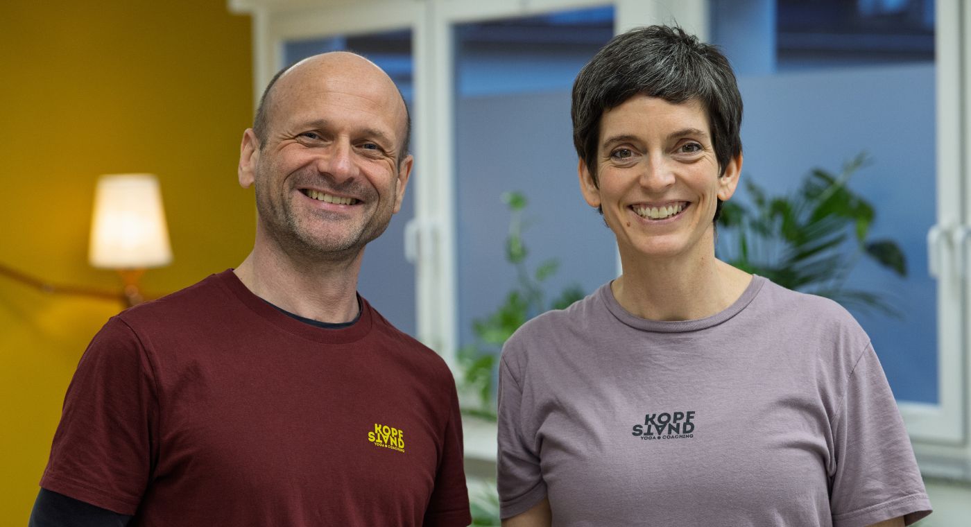 Ein Mann und eine Frau stehen nebeneinander und lächeln in die Kamera.