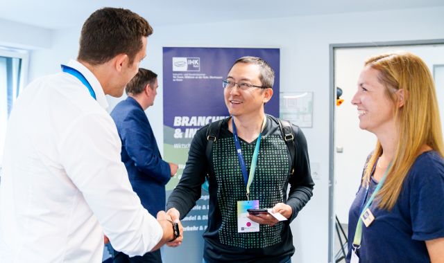 Ein Mann schüttelt einem anderen Mann die Hand. 