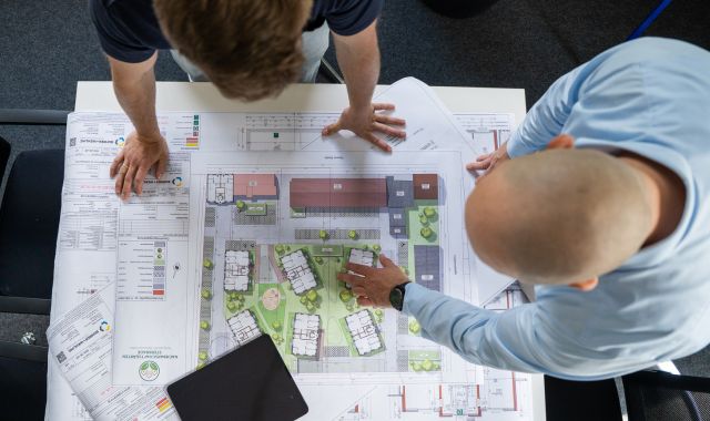 Zwei Männer schauen sich einen Projektplan an.